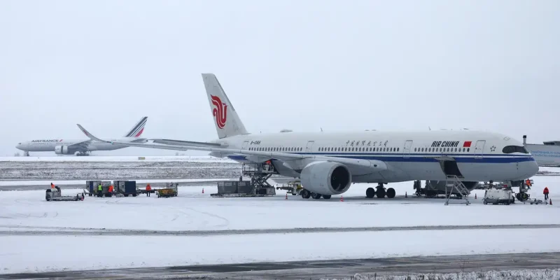 An Air China plane is seen on the snow-covered tarmac at the Paris CDG Terminal 1 of the Paris-Charles de Gaulle Airport, in Roissy-en-France, near Paris, as traffic is disrupted and some flights cancelled due winter weather with snow and cold temperatures on part of the country, France, January 7, 2026. REUTERS/Abdul Saboor