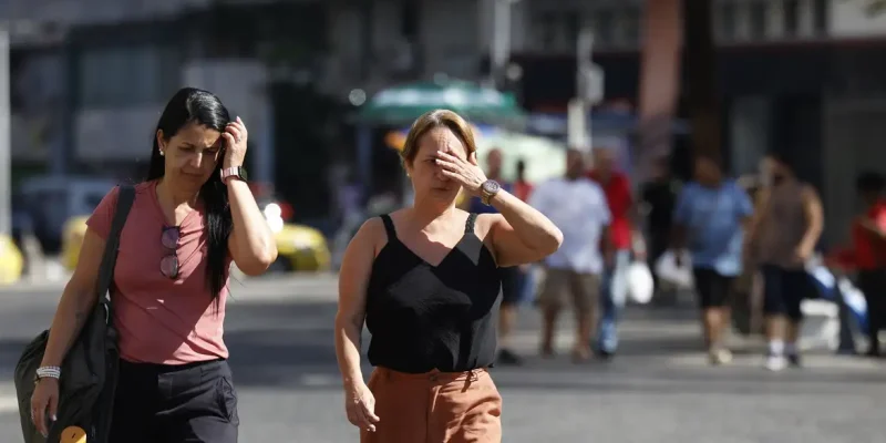 Rio de Janeiro (RJ), 26/12/2025 – Pessoas se protegem do sol no centro da cidade em dia de calor no Rio de Janeiro. Foto: Fernando Frazão/Agência Brasil