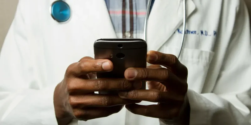 Médico com estetoscópio fala no celular. Foto: National Cancer Institute/Unsplash