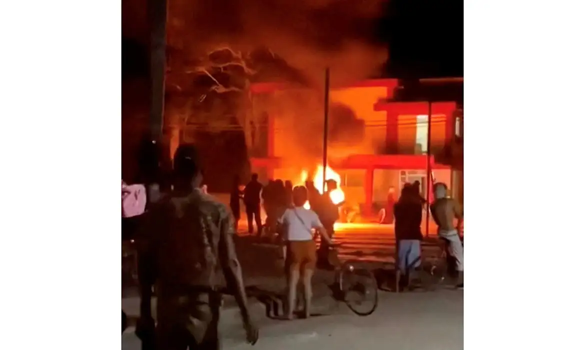 Anti-government protesters look on as a fire burns at a Communist Party office in Moron, Cuba, in this screengrab from video released on March 14, 2026 and obtained from social media. Social Media/via REUTERS  THIS IMAGE HAS BEEN SUPPLIED BY A THIRD PARTY. MANDATORY CREDIT. NO RESALES. NO ARCHIVES.

VERIFICATION:
- Reuters verified the location from the buildings, the trees, the electric poles, and the entrance gate, which matched file and satellite imagery of the area. 
- The date the video was recorded could not be independently verified. However, Cuban state media reported on the protest on March 14. 
- Corroborating videos posted on March 14 also show a fire at the same building. 
- No older versions of the video were found posted online before March 14. 
- Coordinates: 22.097128325165183, -78.63044473362781     TPX IMAGES OF THE DAY