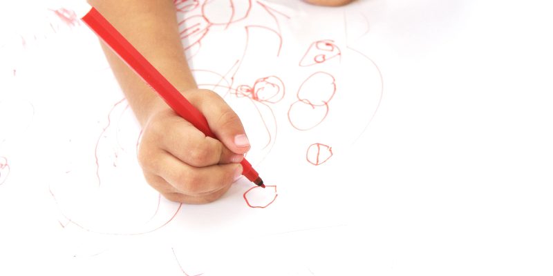 criança desenhando com caneta verm