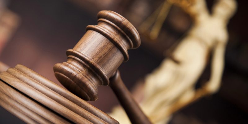 martelo da justiça em plano incial com estatua da justiça ao fundo