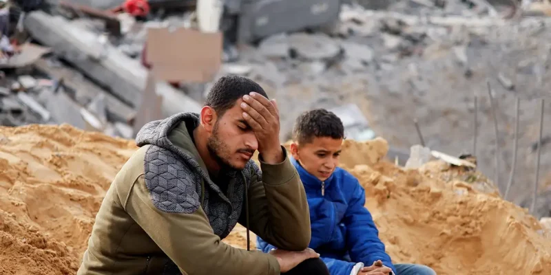 Palestinians react as they sit at the site of an Israeli strike on a house, amid the ongoing conflict between Israel and the Palestinian Islamist group Hamas, in Rafah in the southern Gaza Strip February 23, 2024. REUTERS/Ibraheem Abu Mustafa     TPX IMAGES OF THE DAY