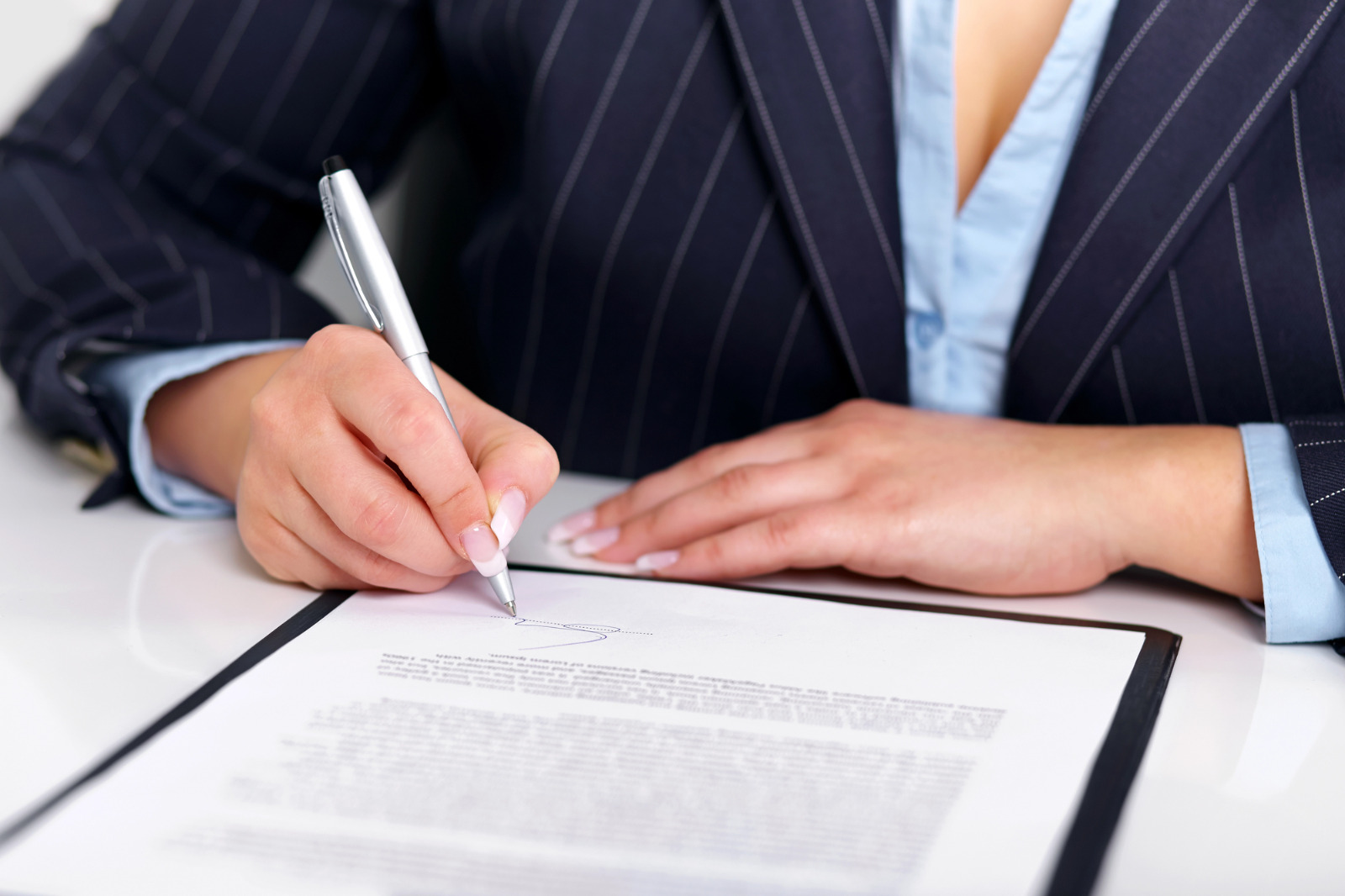 imagem de uma mulher assinando um documento em alusao a recomendacao para o concurso da camara