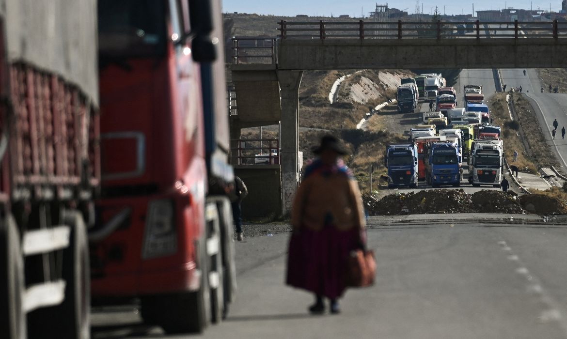A woman walks among trucks stranded for days as protesters block a major highway, demanding the resignation of President Rodrigo Paz amid an ongoing economic and fuel crisis, in Apacheta, Bolivia, May 13, 2026. REUTERS/ Claudia Morales TPX IMAGES OF THE DAY