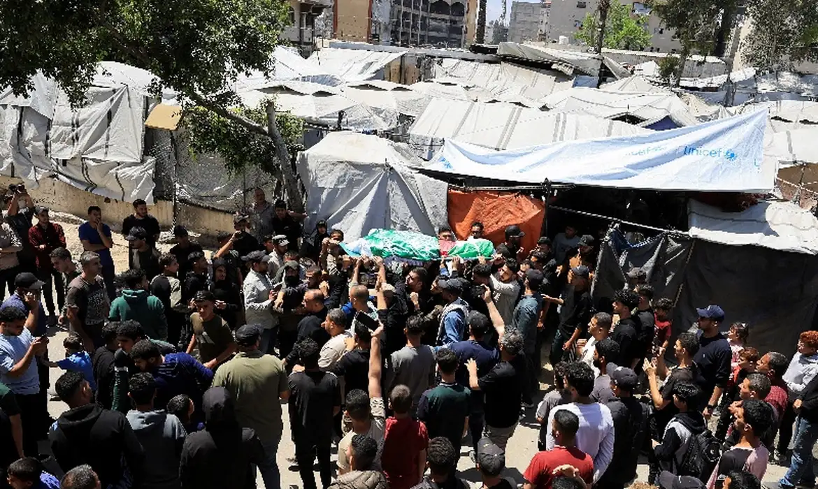 Pessoas carregam um corpo identificado por pessoas de luto como o comandante da ala militar do Hamas, Izz al-Din al-Haddad, que foi morto em um ataque israelense na sexta-feira, durante um funeral, na Cidade de Gaza, em 16 de maio de 2026. REUTERS/Dawoud Abu Alkas