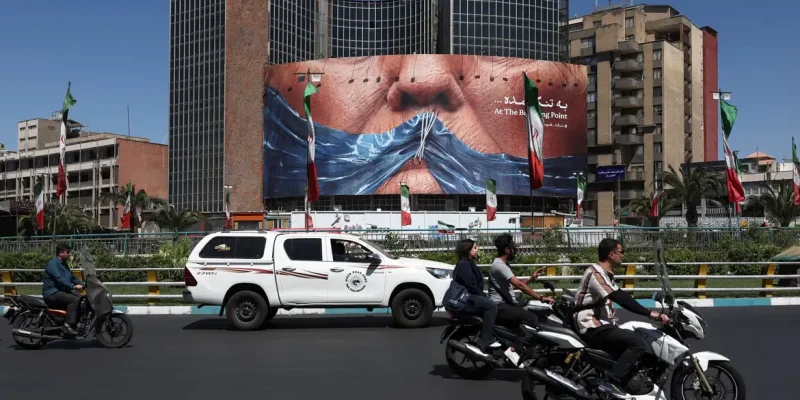 Pessoas passam por outdoor anti-EUA em Teerã
  25 de maio de 2026  Majid Asgaripour/WANA via REUTERS