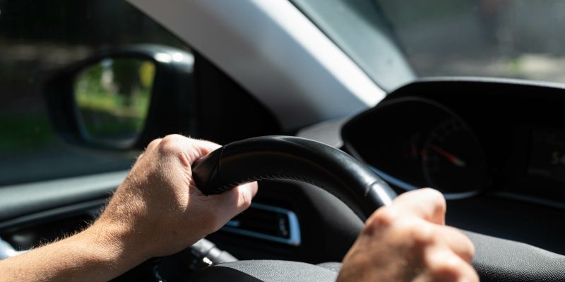 motorista com a mão no volante de um carro em alusão à recomendação para uso regular de frota