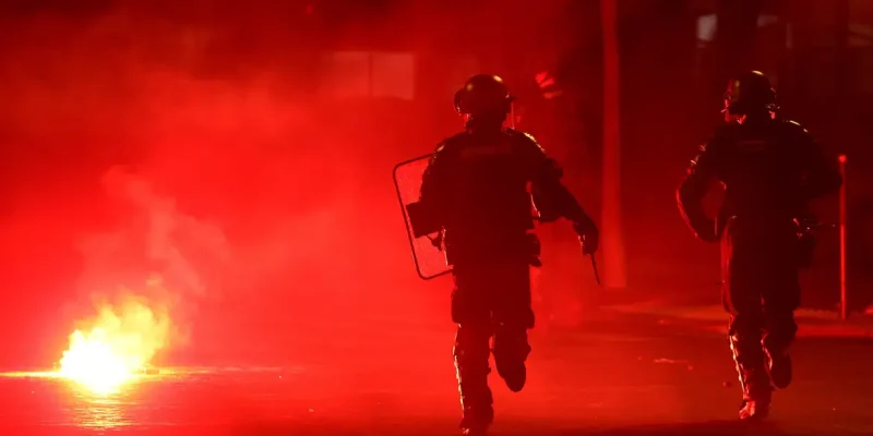 Policiais se protegem de sinalizador em meio a tumulto em Paris durante comemoração do título do Paris St Germain na Liga dos Campeões
31 de maio de 2026 REUTERS/Abdul Saboor