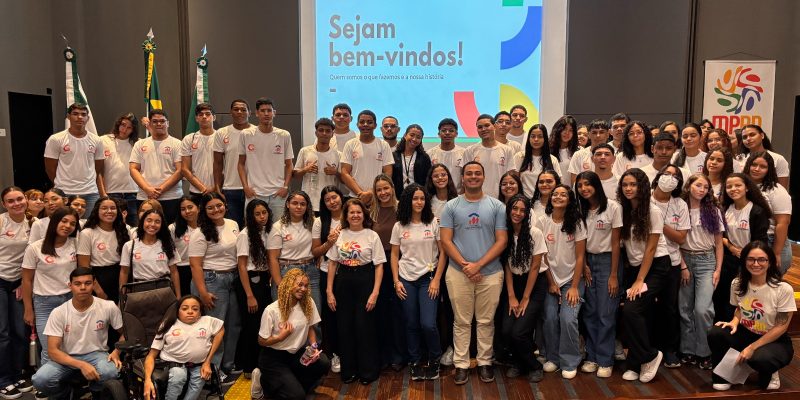 Alunos da Casa do Menor trabalhador em pé no palco do auditorio do mprn