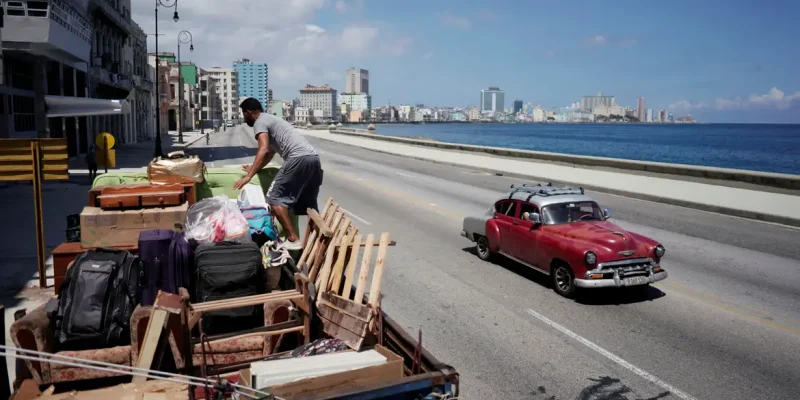 A man loads a truck with furniture from his home prior to the arrival of Storm Elsa, in Havana