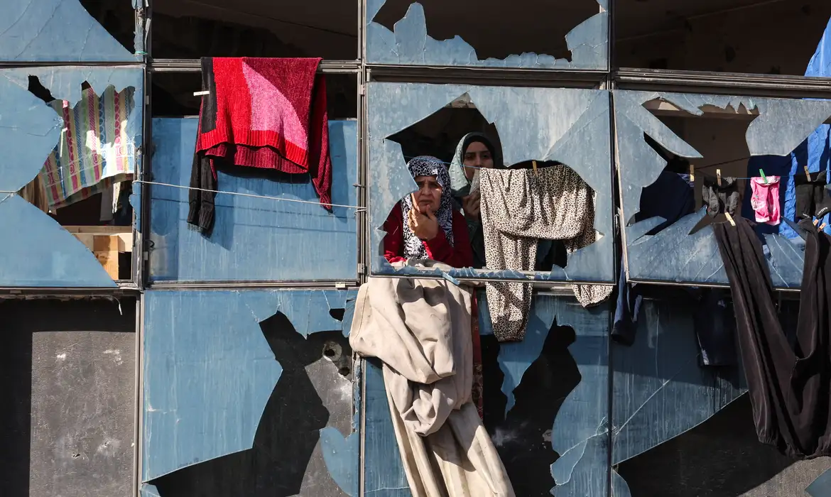 Palestinian women look on from behind broken windows, during the funeral of Palestinians who, according to medics, were killed by an Israeli strike on Saturday, at Al-Shifa Hospital in Gaza City, January 31, 2026. REUTERS/Dawoud Abu Alkas