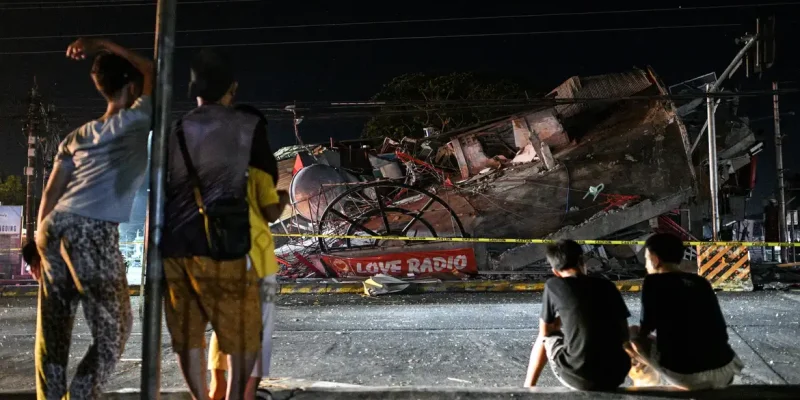 People look at a collapsed building following the magnitude 7.8 quake in General Santos, southern Philippines, June 8, 2026. REUTERS/Noel Celis