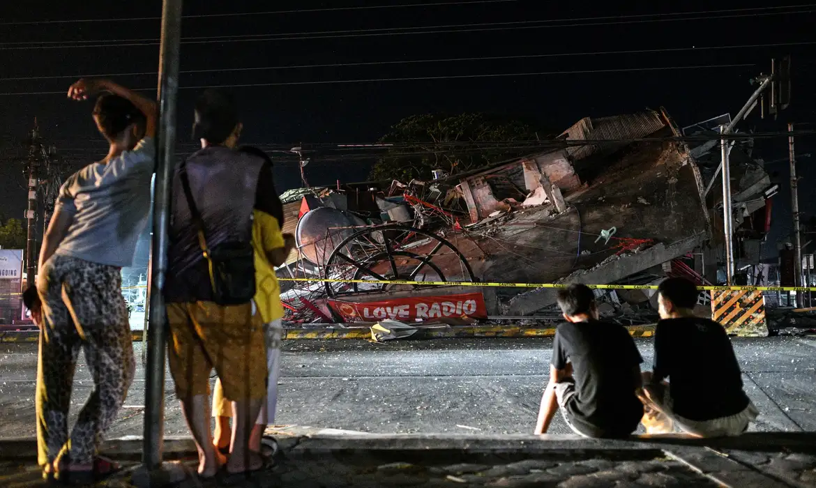 People look at a collapsed building following the magnitude 7.8 quake in General Santos, southern Philippines, June 8, 2026. REUTERS/Noel Celis