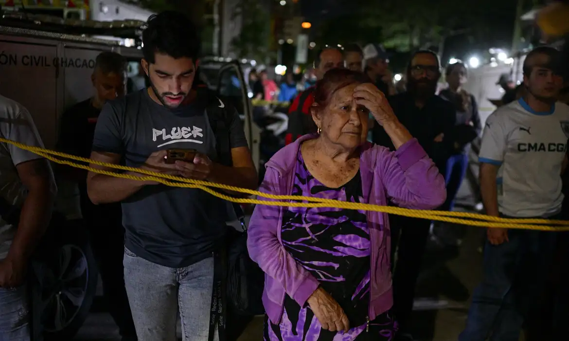 People stand at the site of a collapsed building, after an earthquake, in Caracas, Venezuela, June 25, 2026. REUTERS/Gaby Oraa