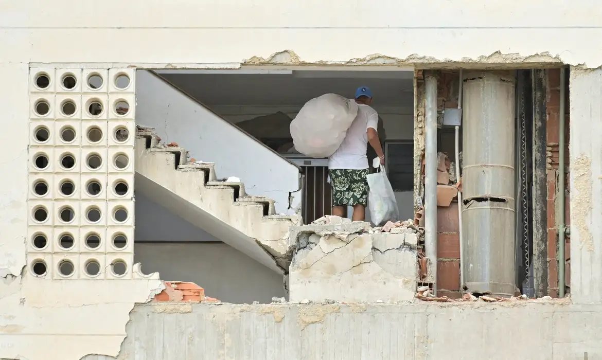 A man carrying belongings walks in a damaged building, after earthquakes hit the country, in La Guaira, Venezuela, June 28, 2026. REUTERS/Maxwell Briceno     TPX IMAGES OF THE DAY