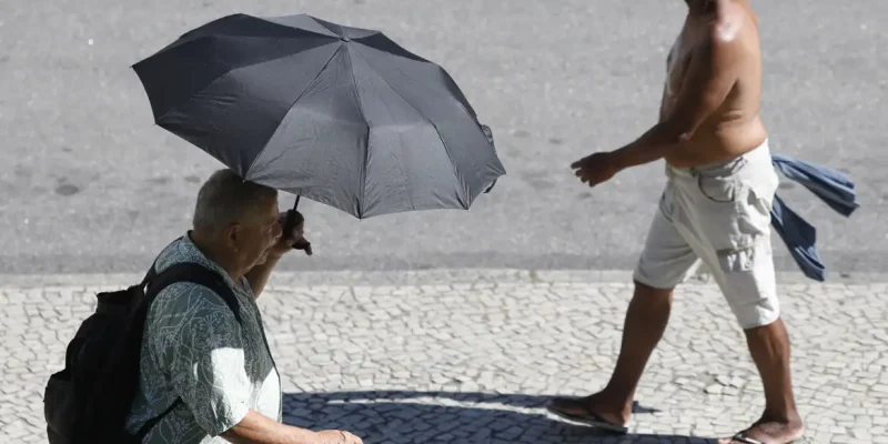 Rio de Janeiro (RJ), 26/12/2025 – Pessoas se protegem do sol no centro da cidade em dia de calor no Rio de Janeiro. Foto: Fernando Frazão/Agência Brasil