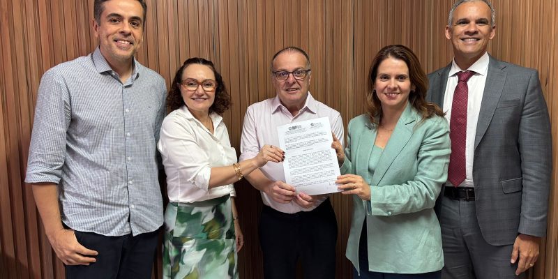 cinco pessoas em pé segurando um papel
