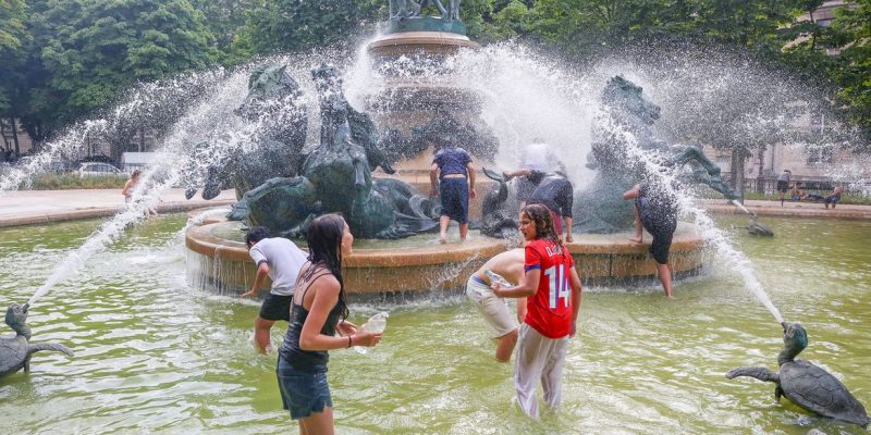 Young people cool off in the Fontaine de l'Observatoire fountain as temperatures rise in Paris and a heatwave hits a large part of France, June 18, 2026. REUTERS/Abdul Saboor