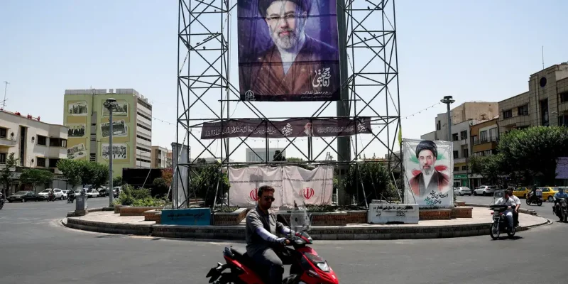 Pessoas passam de motocicleta por um banner com a foto do Líder Supremo do Irã, Mojtaba Khamenei, em Teerã, Irã, em 28 de junho de 2026
Majid Asgaripour/WANA via REUTERS