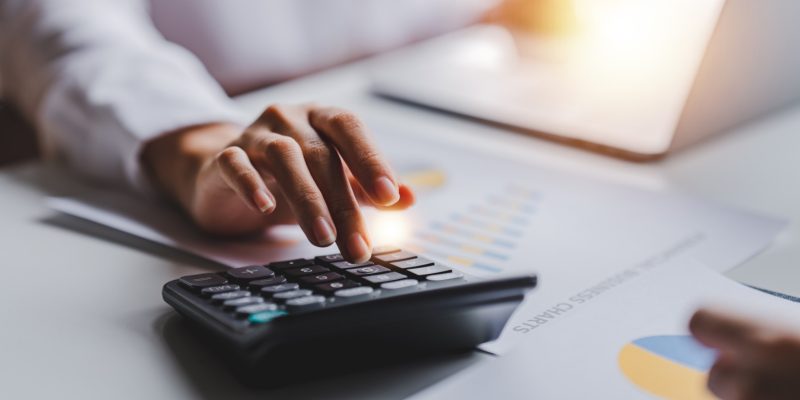 Imagem mostra mao masculina fazendo contas em calculadora