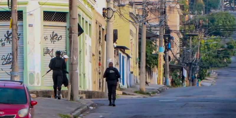 Two armed police officers walk through an almost deserted street in Rio De Janeiro. At least eleven people have died in a police operation against the heads of the Comando Vermelho (Red Command) Criminal organization. (Best possible quality)