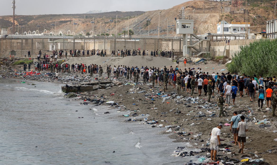 People walk towards the border with Morocco leaving Spain, amid mass crossings of migrants on foot and by sea from Morocco into Spanish territory, in Ceuta, Spain, July 31, 2026. REUTERS/Jon Nazca     TPX IMAGES OF THE DAY
