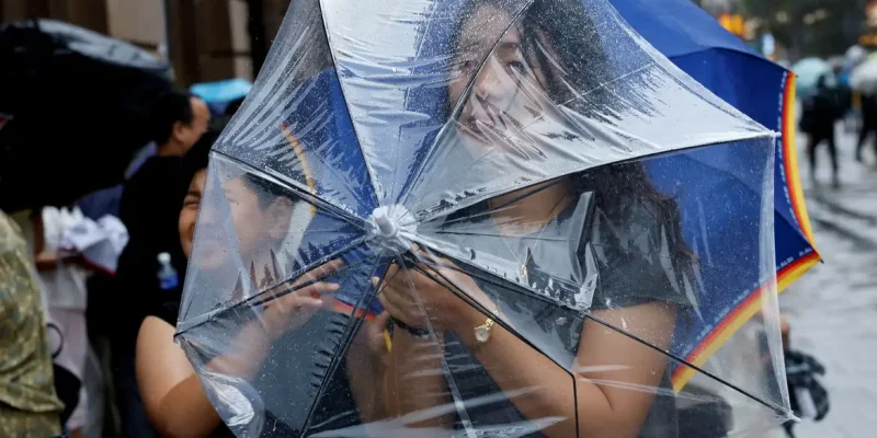 Uma pessoa segura um guarda-chuva para se proteger dos ventos fortes antes da chegada do tufão Dolphin em Xangai, na China, em 9 de agosto de 2026. REUTERS/Go Nakamura