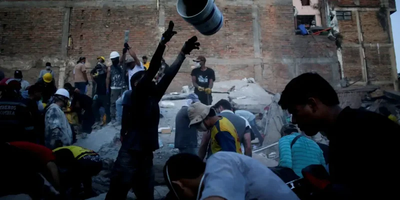 Pessoas recolhem escombros no local onde um prédio ruiu em Pereira, na Colômbia, após o terremoto de segunda-feira. August 11, 2026. REUTERS/Juan David Duque     TPX IMAGES OF THE DAY