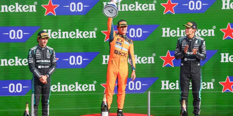 Formula One F1 - Dutch Grand Prix - Circuit Zandvoort, Zandvoort, Netherlands - August 23, 2026
McLaren's Lando Norris celebrates on the podium with the trophy after winning the Dutch Grand Prix alongside second placed Mercedes' Andrea Kimi Antonelli and third placed Mercedes' George Russell REUTERS/Jakub Porzycki     TPX IMAGES OF THE DAY