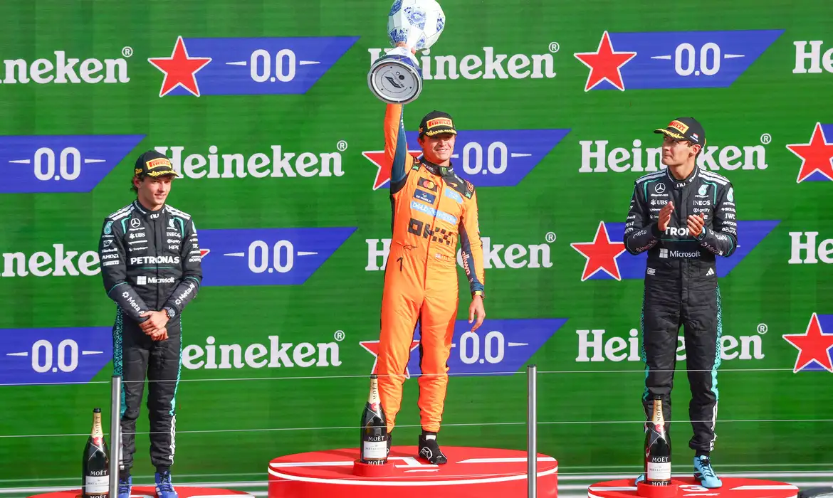 Formula One F1 - Dutch Grand Prix - Circuit Zandvoort, Zandvoort, Netherlands - August 23, 2026
McLaren's Lando Norris celebrates on the podium with the trophy after winning the Dutch Grand Prix alongside second placed Mercedes' Andrea Kimi Antonelli and third placed Mercedes' George Russell REUTERS/Jakub Porzycki     TPX IMAGES OF THE DAY