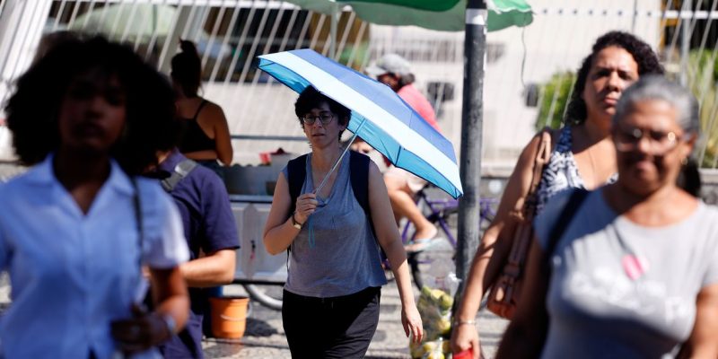 Rio de Janeiro (RJ), 17/02/2024 -Transeuntes se protegem do forte calor nas ruas do centro da cidade. Cidade do Rio de Janeiro atinge nível 4 de calor. Marco é caracterizado por temperaturas que podem chegar a 44ºC  Foto: Tânia Rêgo/Agência Brasil